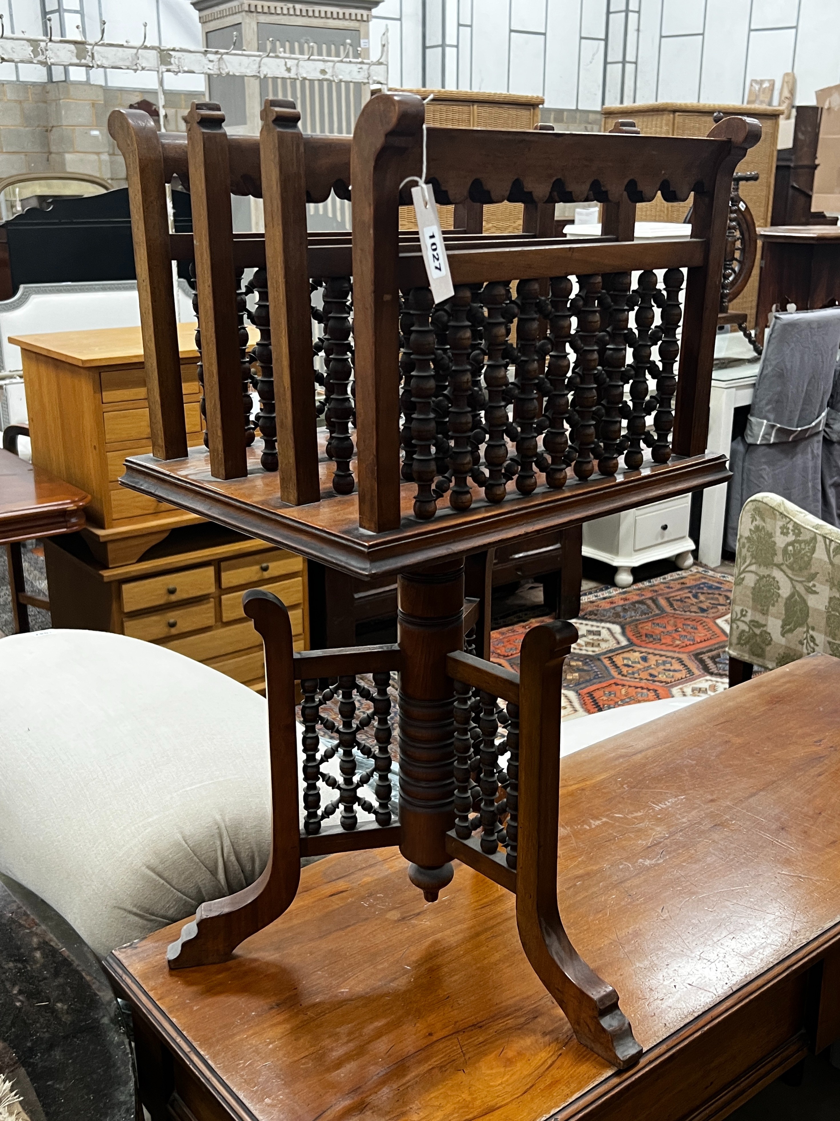 An early 20th century Moorish style walnut three division revolving newspaper stand, width 42cm, depth 34cm, height 76cm